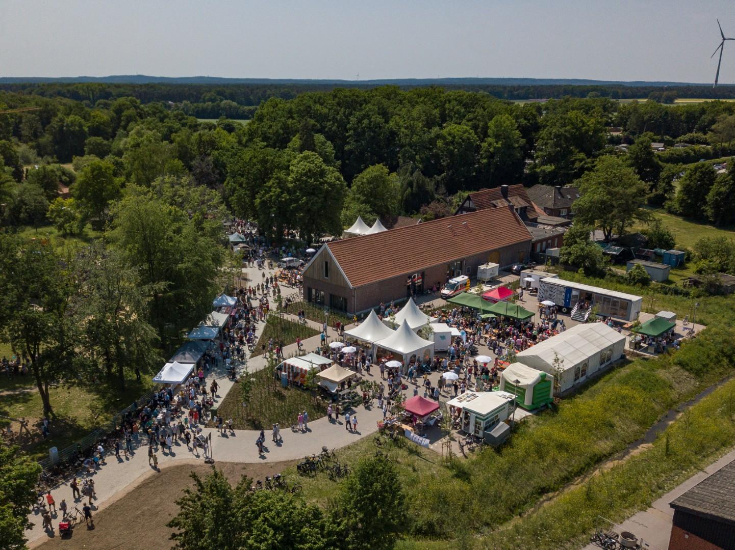 Luftaufnahme des Steverauenfestes: Zu sehen sind zahlreiche Stände und Besucher rundum das Naturparkhaus Steveraue.