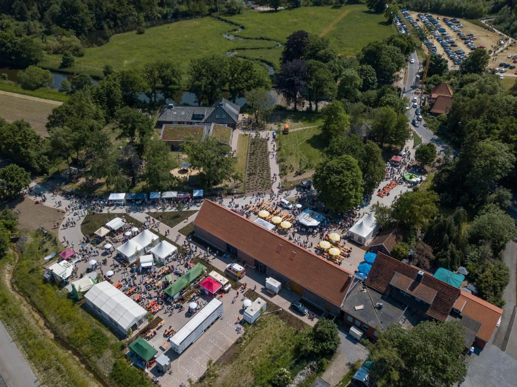 Luftaufnahme des Steveraunfestes: Zu sehen sind zahlreiche Besucher und Stände rundum das Naturparkhaus Steveraue.