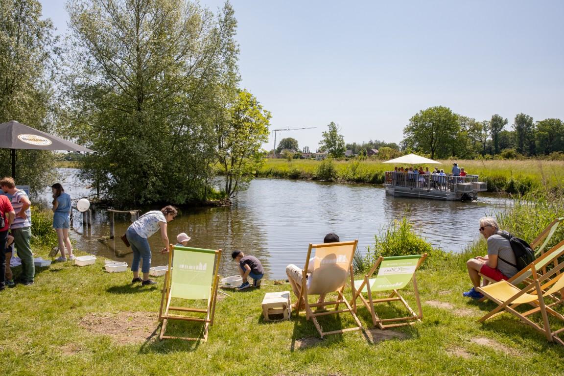 Picknickliegen, Besucher, neugierige Kinder an der Stever und im Hintergrund ist das Floß am Floßanleger zu erkennen.