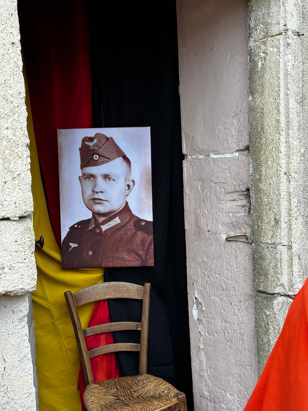Grundschüler gestalteten die Tür an der Pfarrer Heinrich Niewind die Besatzungspolizei erwartete (Foto: Stadt Olfen) Zu sehen ist ein Foto von Pfarrer Heinrich Niewind und die deutsche Flagge.