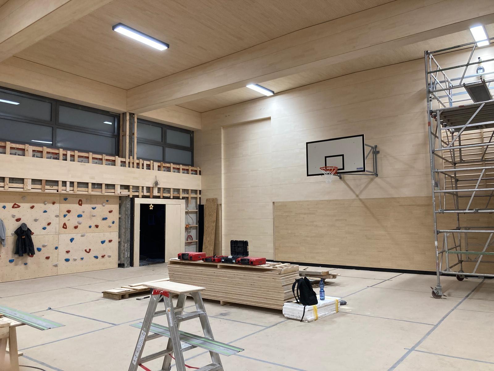 Die Geestturnhalle hat bereits neue Holzdecken und -wände und einen neuen Boden. Zu sehen sind außerdem ein Basektballkorb sowie eine Kletterwand für Kinder.