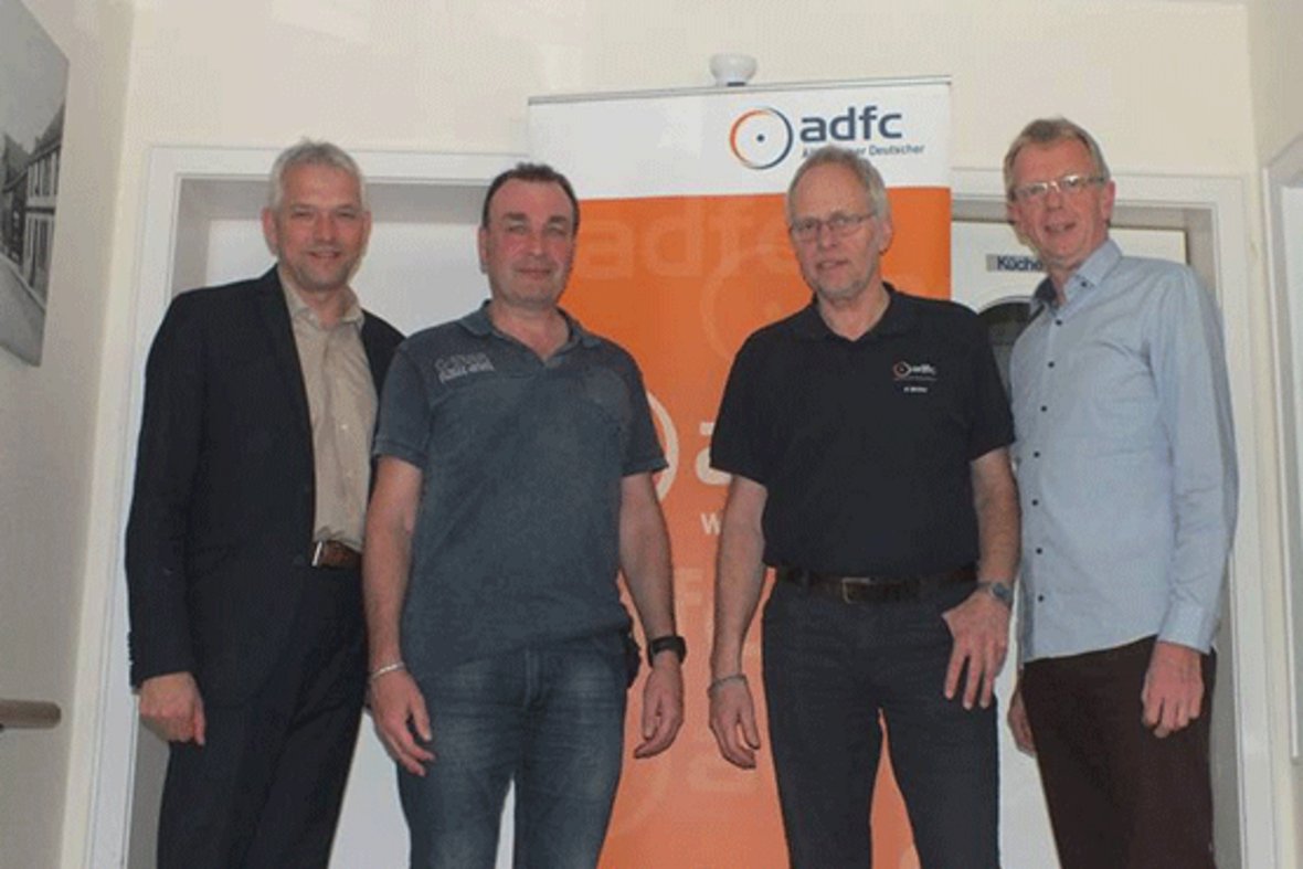 Bürgermeister Wilhelm Sendermann und drei weitere Personen der ADFC-Ortsgruppe stehen vor einem Roll-Up vom ADFC.