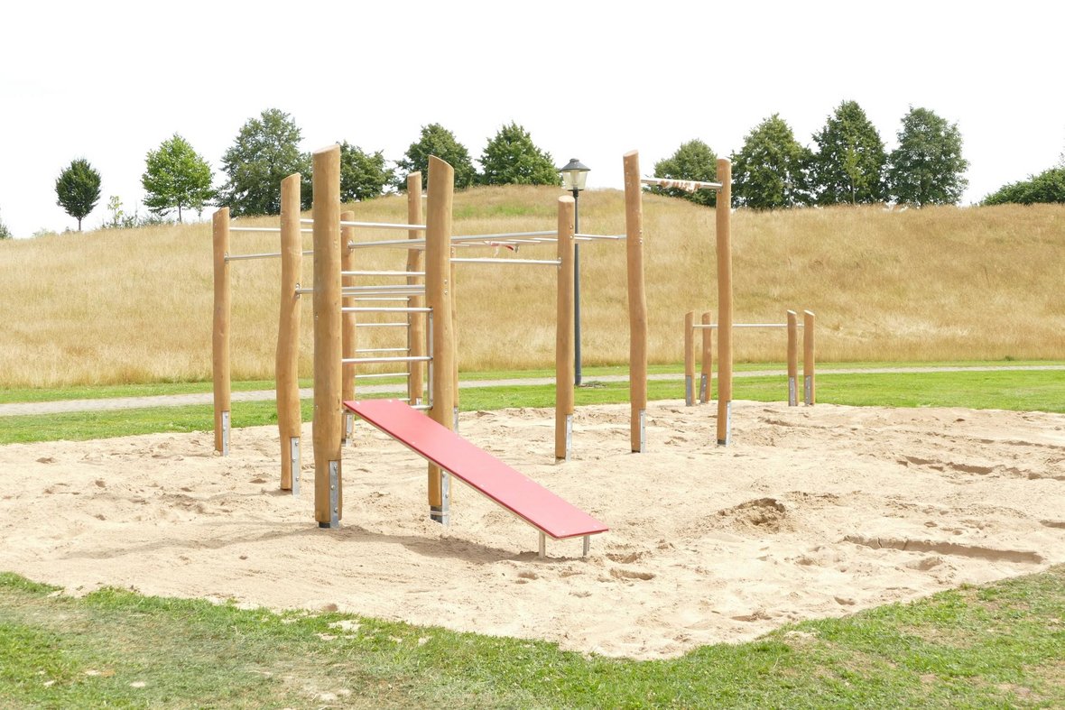 Die Calisthenics-Anlage mit sandigem Untergrund steht im St. Vitus Park mit verschiedenen Turn- und Sportmöglichkeiten.