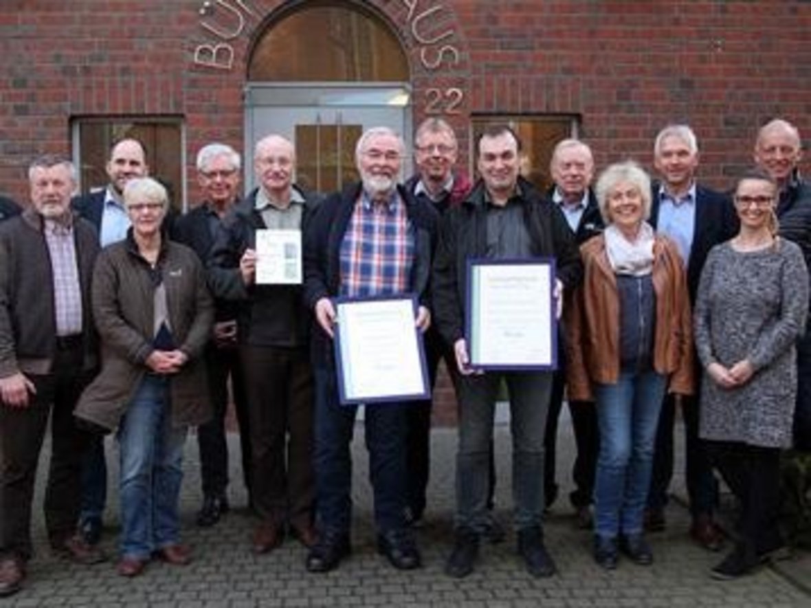 Bürgermeister Wilhelm Sendermann und die damalige Klimaschutzbeauftragte Sarah Ludwiczak gratulieren den Gewinnern des Umweltpreises 2017 vor dem Bürgerhaus der Stadt Olfen.