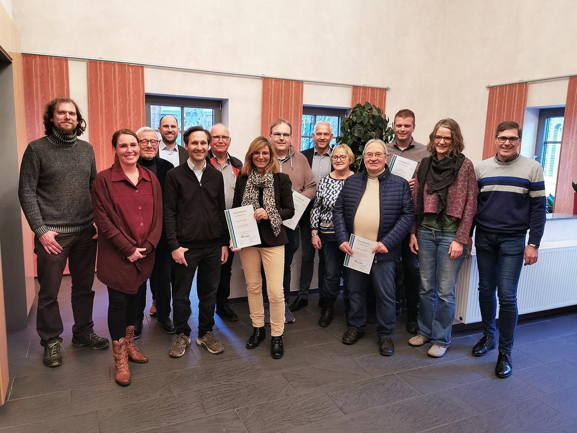 Bürgermeister Wilhelm Sendermann und die damalige Klimaschutzbeauftragte Jana Temiz gratulieren den Gewinnern des Umweltpreises 2022 im Bürgerhaus der Stadt Olfen.