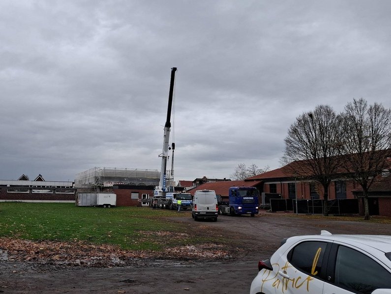 Außenansicht des Gebäudes aus Sicht der Festwiese hinter der Stadthalle. Ein Kran und Baugerüst sind zu erkennen.