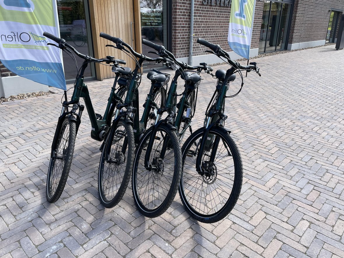 Vier E-Bikes stehen vor dem Eingang des Naturparkhauses Steveraue.