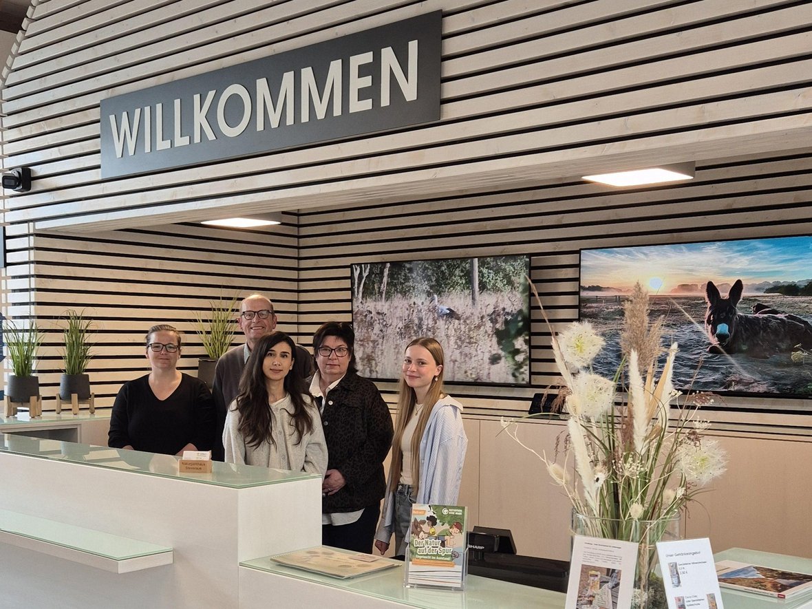 Die Mitarbeiter des Naturparkhauses stehen hinter der Empfangstheke.