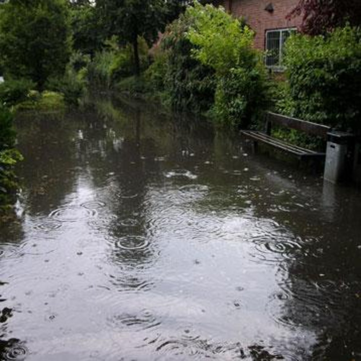 Zu sehen ist ein Gehweg der unter Hochwasser steht.