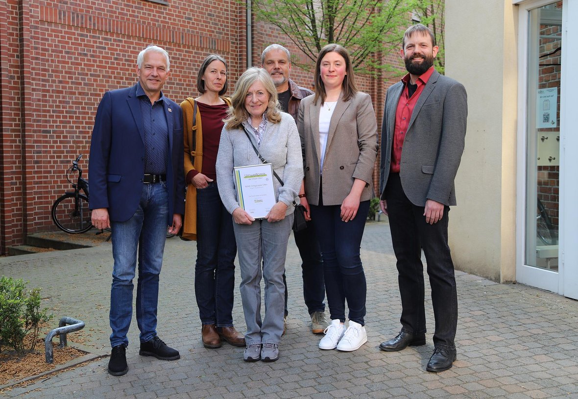 Auf dem Foto sind Mitglieder des BUND Ortsgruppe Olfen zu sehen, die den Umweltpreis 2025/2026 erhalten haben, sowie Vertreter der Stadt Olfen und der GENREO.