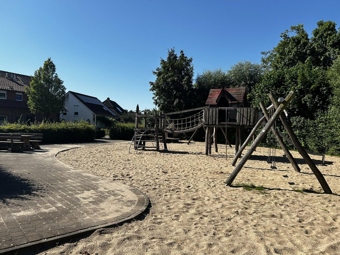 Das Foto zeigt einen Bereich des Spielplatzes an der Alfred-Nobel-Straße in Olfen. Hierauf sind eine Spielgerüst sowie eine Schaukel im Sandbereich zu erkennen.