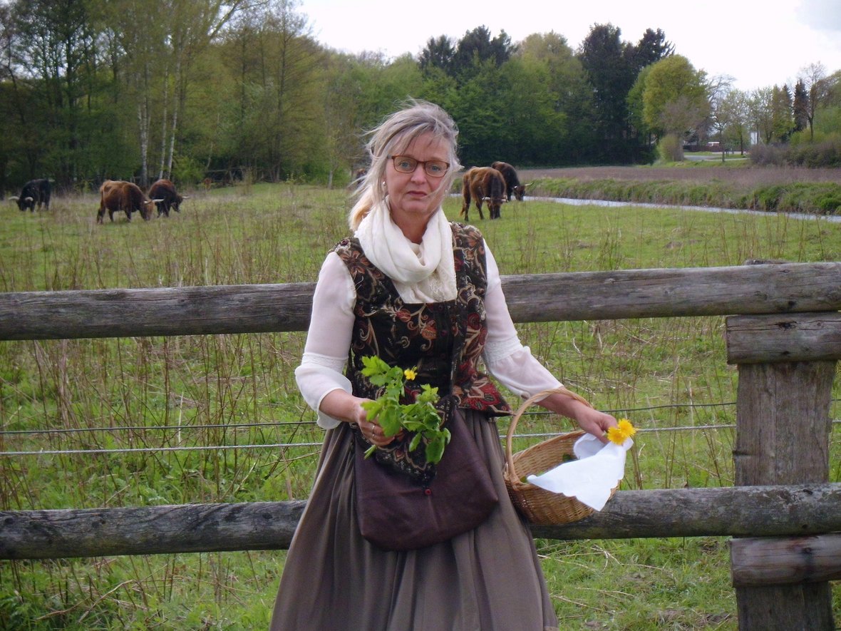 Naturkundeführerin Barbara Zuz macht Kräuterführungen in Olfen. Sie steht mit Kräutern und einem geflochtenen Korb in der Hand in der Steveraue.