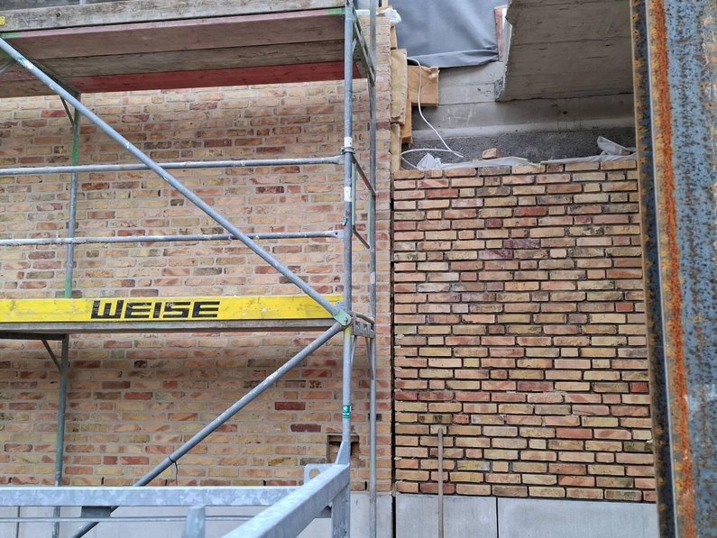 Auf dem Foto ist die Außenfassade des Gebäudes zur erkennen. Eine Seite wurde bereits verfugt, die andere Seite noch nicht.