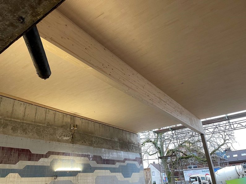 Auf dem Foto ist die neu eingesetzte Lignotrend-Decke im Schwimmhallenbereich zu sehen.