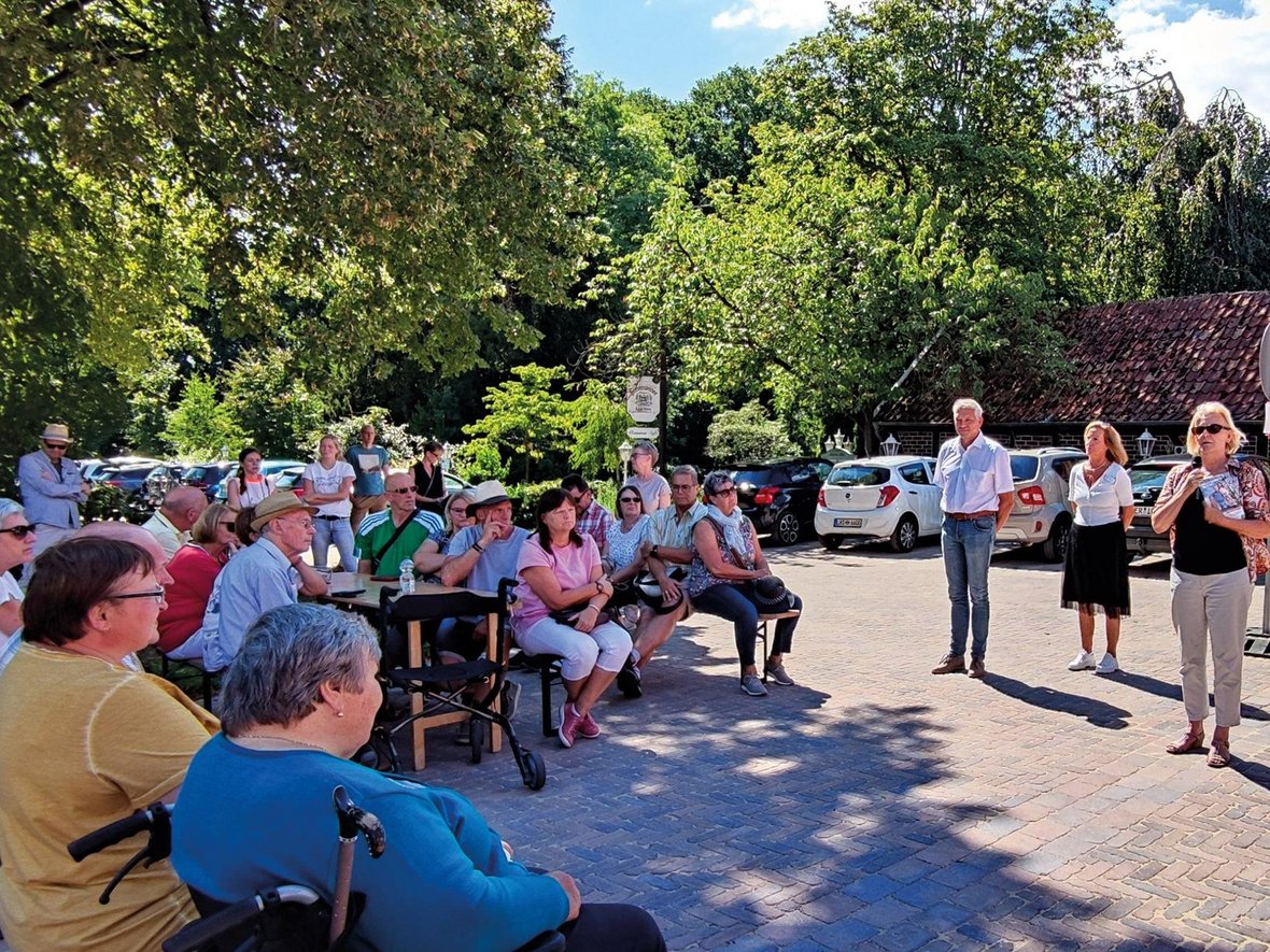 Bürgermeister Sendermann, Vertreter von MiO und den Kirchen stehen auf der Fläche vor dem Naturparkhaus und begrüßen die Neubürgerinnen und Neubürger in Olfen.