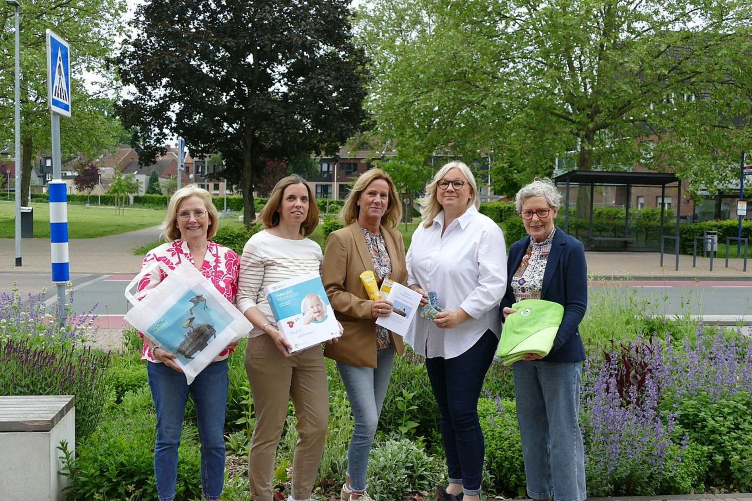 Die Besuchsmütter freuen sich auf die Neugeborenen und deren Familien. Nicole Kortenbusch, Barbara Närmann, Doris Sendermann, Daniela Sube, Agnes Himmelmann (v.l.) Sie stehen vor dem Stadtpark und halten verschiedene Materialien, die bei einem Neugeborenenbesuch übergeben werden, in den Händen, wie z. B. eine Tasche, eine Infomappe und ein grünes Handtuch mit der Stickerei "Olfener Kind".