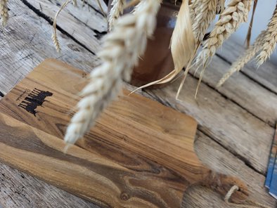 Das Servierbrett aus Holz hat unten ein kleines Branding mit den Silhouetten von Wildpferd, Heckrind und Poitou-Esel und der Aufschrift "Steverauenliebe".