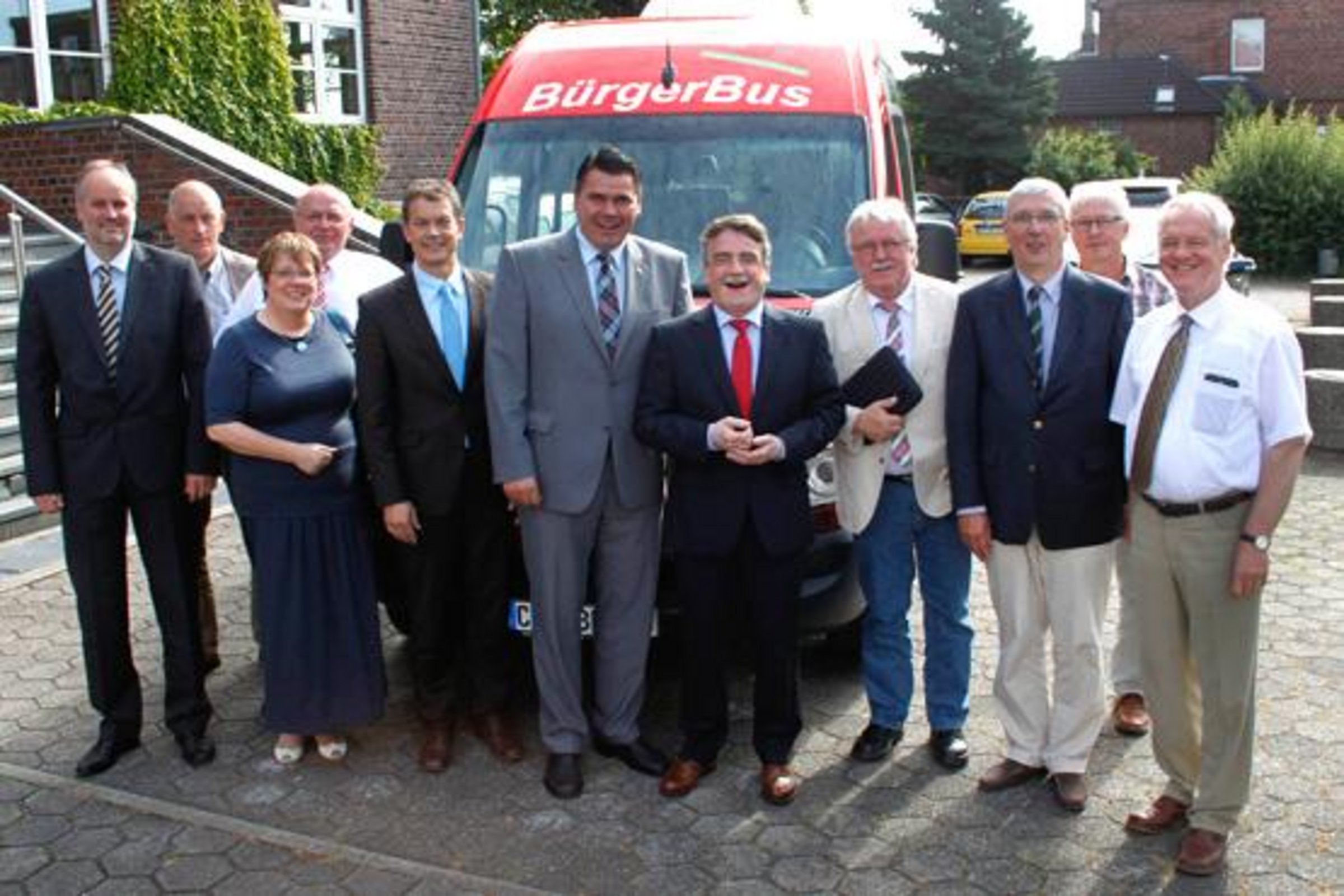 Minister Groschek zu Besuch in Olfen; mehrere Personen stehen vor dem Leohaus am Bürgerbus der Stadt Olfen