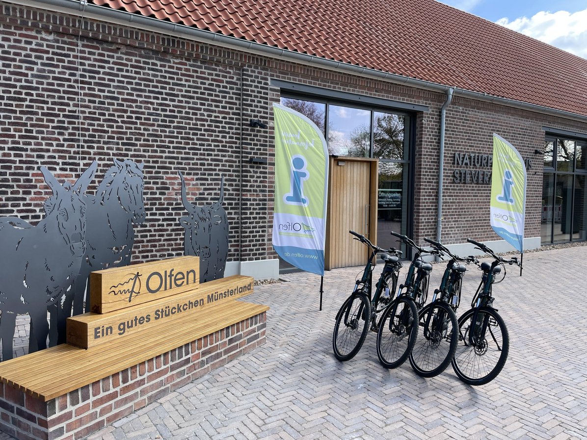 Vier der ausleihbaren E-Bikes vom Naturparkhaus stehen vor dem Fotopoint des Naturparkhauses Steveraue.