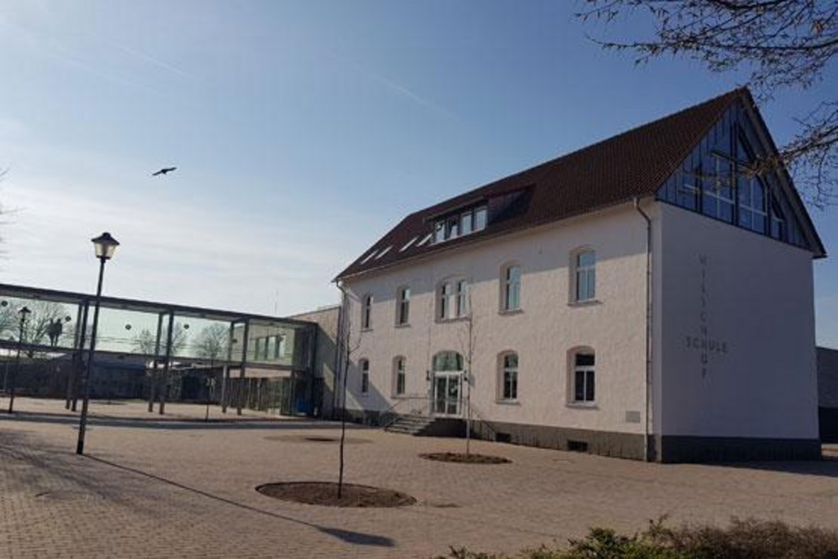 Zu sehen ist das rechte Gebäude der Wieschhofschule in Olfen. Im Vordergrund ist ein Teil des Schulhofes zu sehen.
